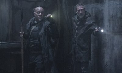 Gabriel e Negan apontando lanternas para algo no metrô do episódio 1 da 11ª e última temporada de The Walking Dead.