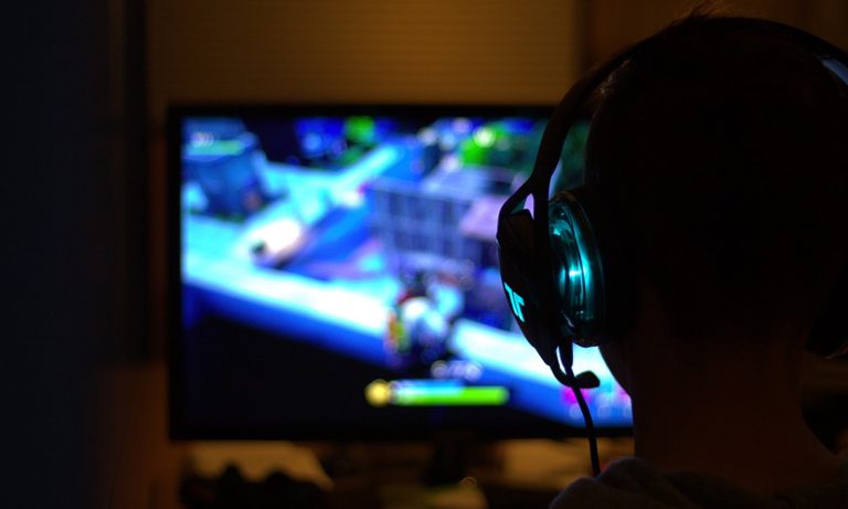 Menino jogando com fone de ouvido e fazendo gameplay.