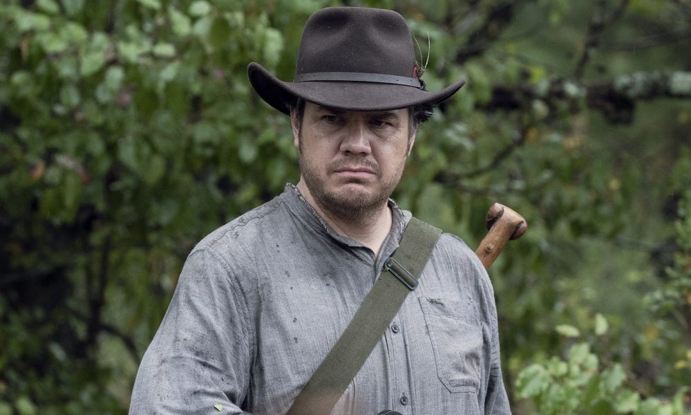 Josh McDermitt como Eugene Porter segurando sua arma em cena da 10ª temporada de The Walking Dead.