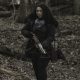 Iris segurando sua crossbow na floresta no episódio 1 da 2ª temporada de The Walking Dead: World Beyond.