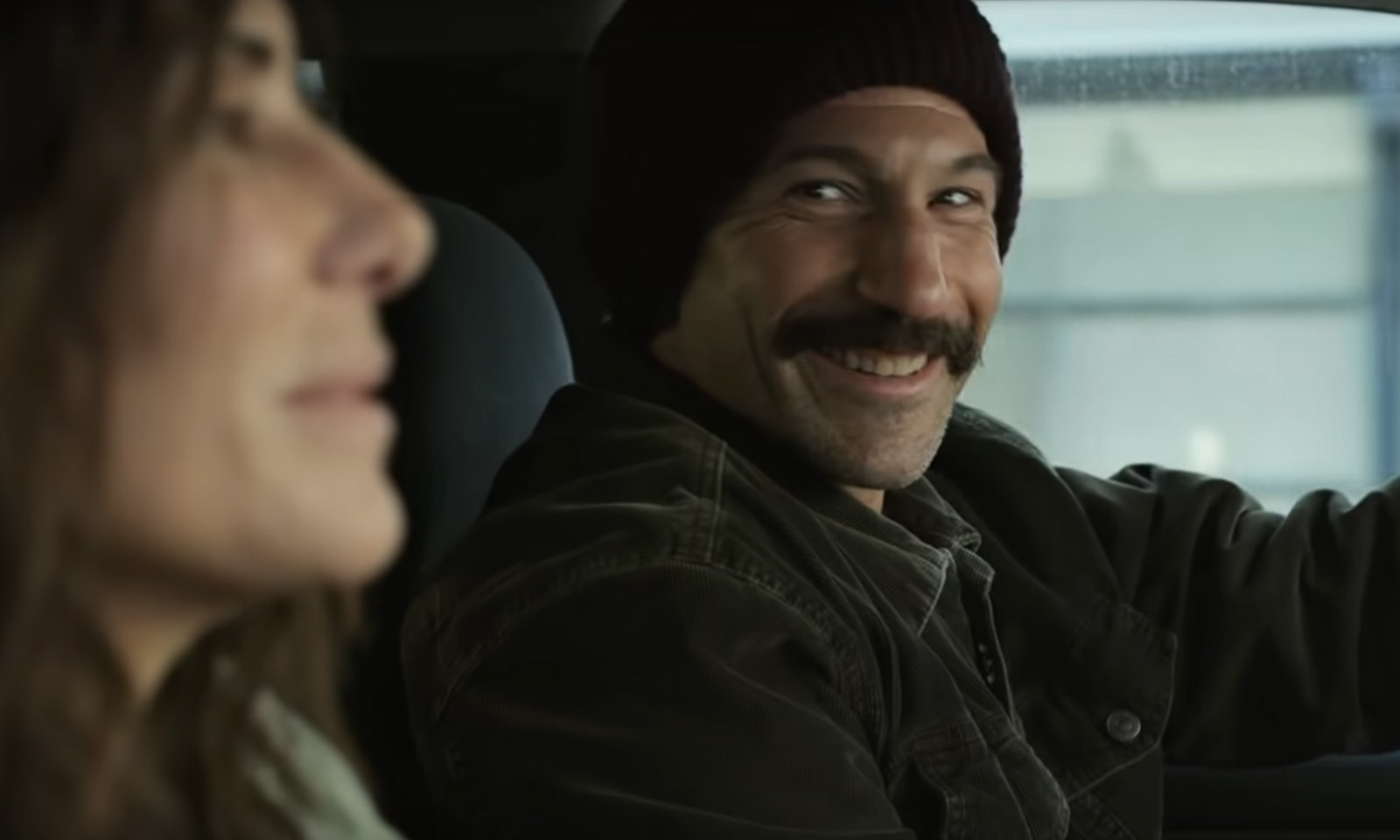 Personagem de Jon Bernthal sorrindo em cena do trailer de Imperdoável, da Netflix.