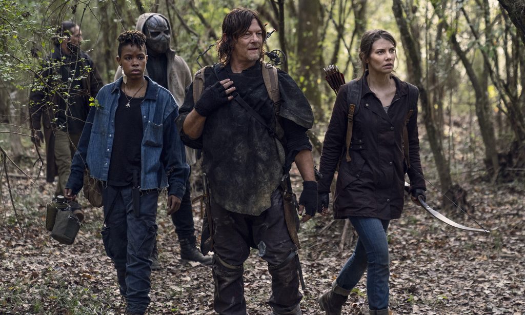 Daryl, Maggie, Kelly e outros na floresta olhando para algo no episódio 17 da 10ª temporada de The Walking Dead.
