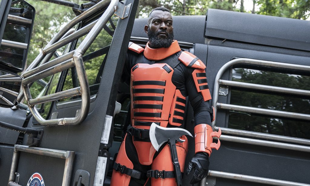 Mercer com sua armadura laranja em um carro em um episódio da segunda parte da 11ª temporada de The Walking Dead.