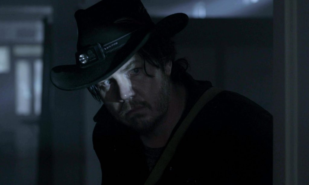 Eugene desconfiado e olhando para algo ou alguém em cena do episódio 11 da 11ª temporada de The Walking Dead.