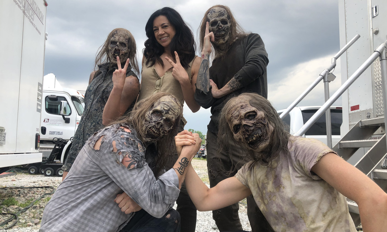Anna Khaja cercada por figurantes dos walkers nos bastidores de The Walking Dead World Beyond.
