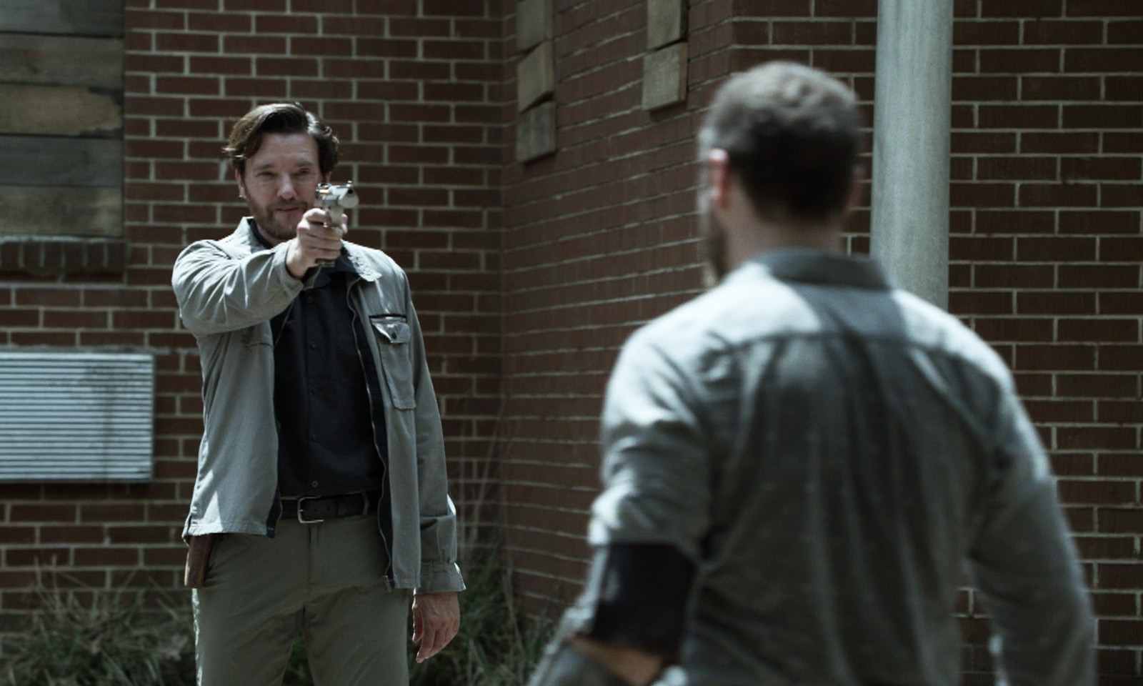 Toby apontando uma arma para Aaron em cena do episódio 13 da 11ª temporada de The Walking Dead.