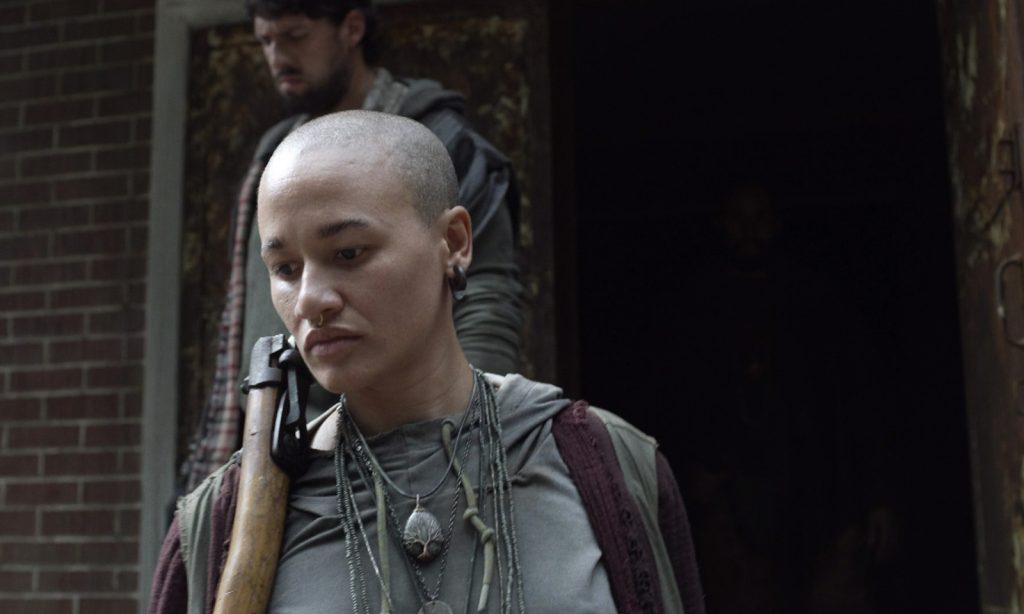 Personagem desconhecida segurando sua arma em cena do episódio 13 da 11ª temporada de The Walking Dead.