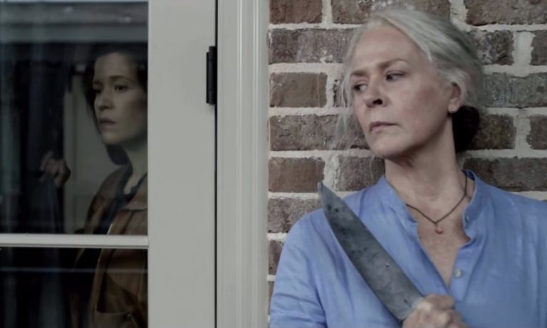 Carol segurando uma faca e se escondendo da Stephanie Fake em cena da terceira parte da 11ª temporada de The Walking Dead.