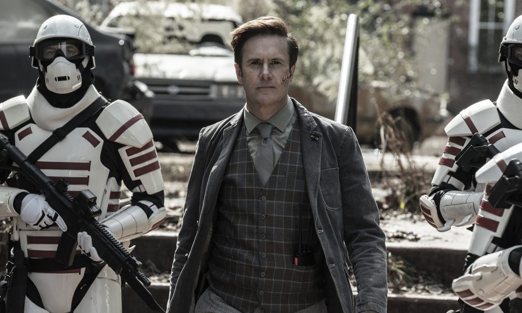 Lance andando ao lado de dois soldados em cena do episódio 17 da última temporada de The Walking Dead.