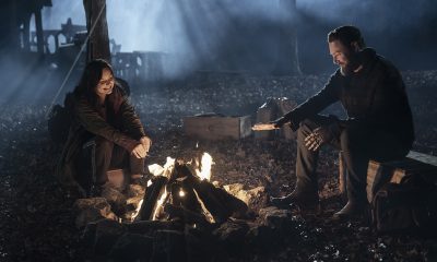 Aaron e Lydia sentados a noite ao redor da fogueira em cena do episódio 19 da 11ª temporada de The Walking Dead.