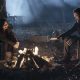 Aaron e Lydia sentados a noite ao redor da fogueira em cena do episódio 19 da 11ª temporada de The Walking Dead.