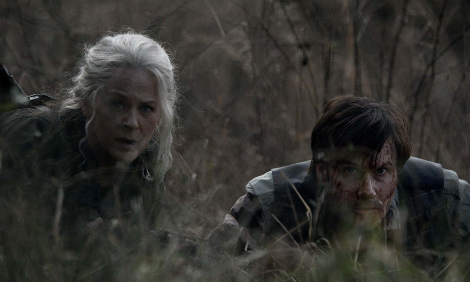 Carol e Lance escondidos no mato em cena do episódio 20 da 11ª temporada de The Walking Dead.