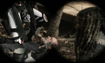Negan sendo rendido no chão por um soldado de Commonwealth com Ezekiel de lado em cena do episódio 22 da 11ª temporada de The Walking Dead.