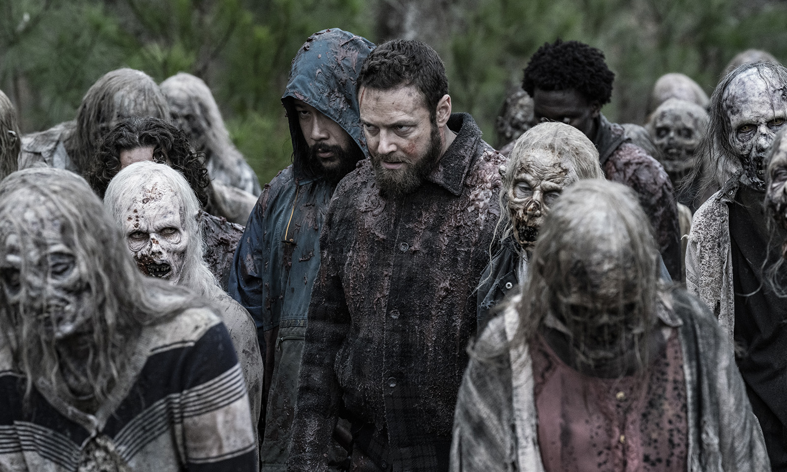 Aaron, Jerry e Elijah andando entre os walkers da horda em cena do episódio 23 da 11ª temporada de The Walking Dead.