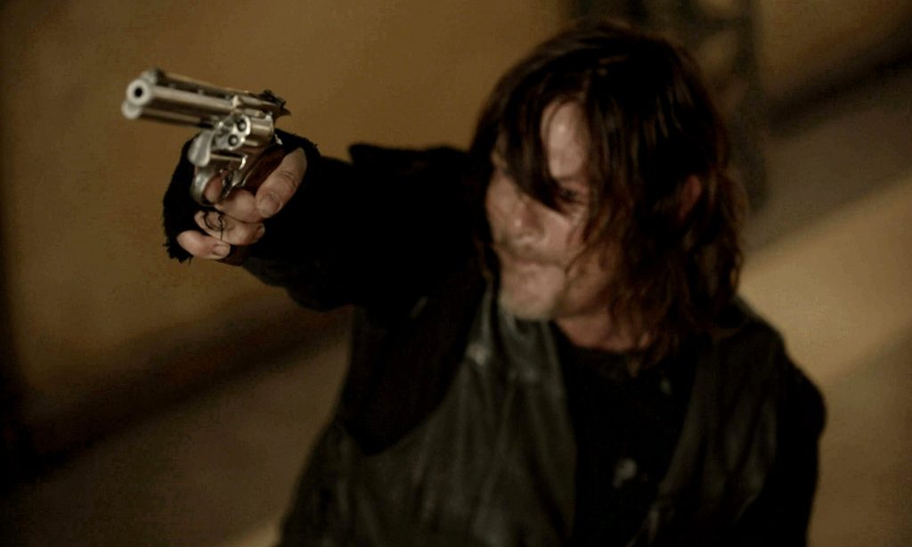Daryl apontando o revólver para alguém em cena do episódio 23 da 11ª temporada de The Walking Dead.