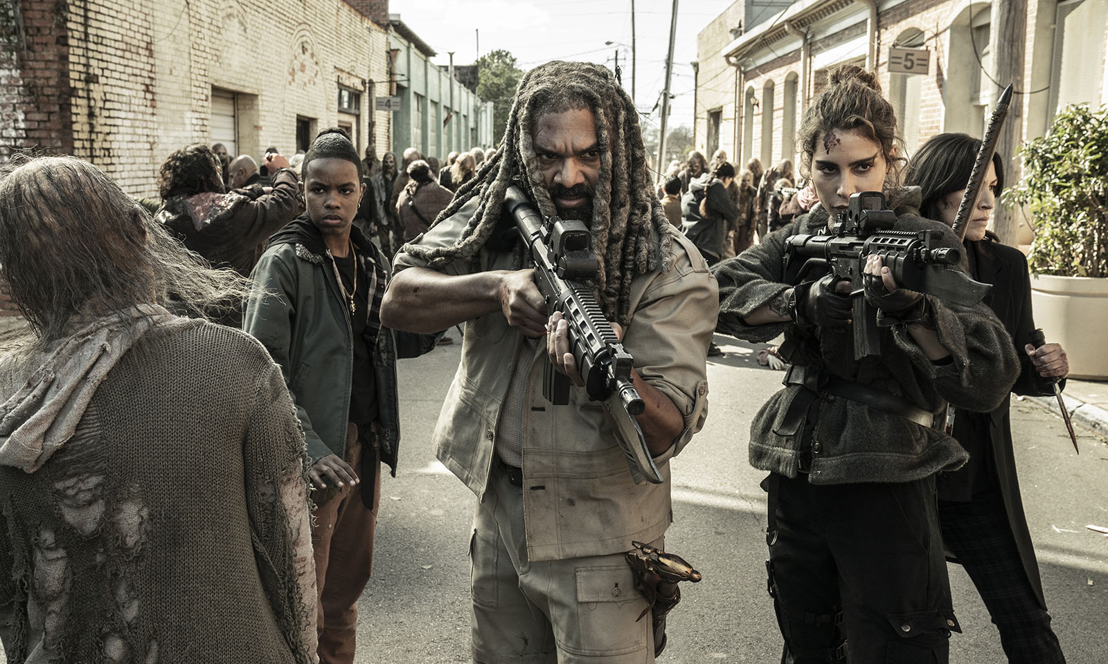Ezekiel, Magna e Kelly apontando suas armas em meio aos walkers em cena do último episódio de The Walking Dead.