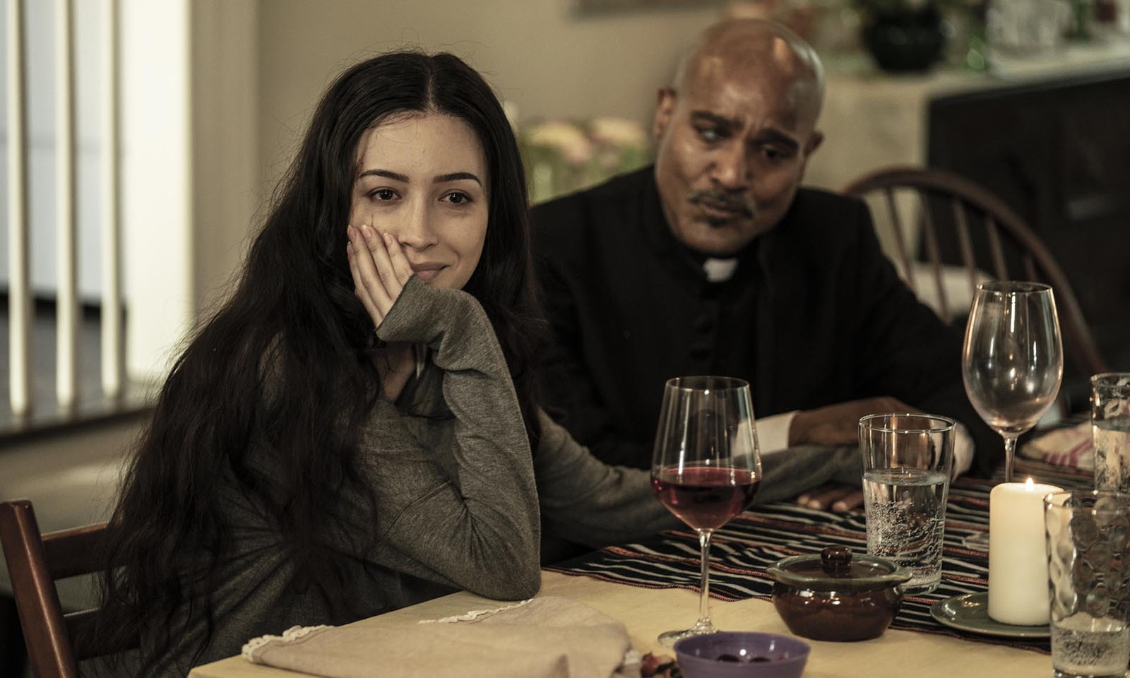 Rosita sentada a mesa segurando a mão de Gabriel em cena do último episódio de The Walking Dead.