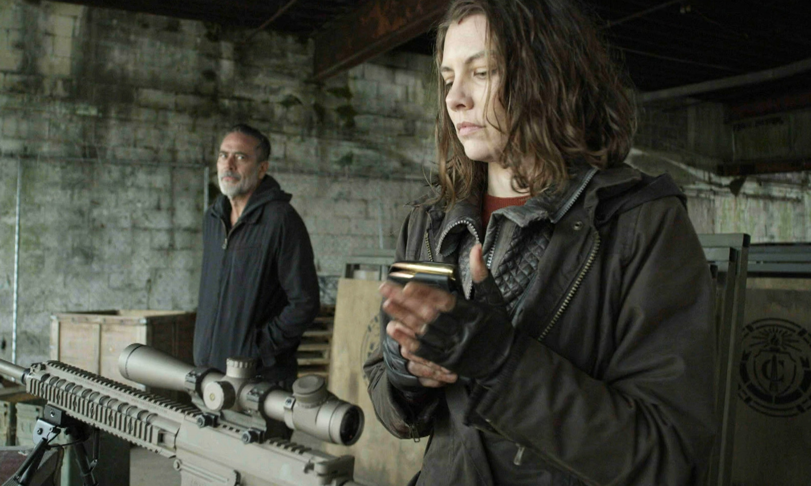 Maggie preparando sua arma enquanto Negan a observa em cena do episódio 24 da 11ª temporada de The Walking Dead.