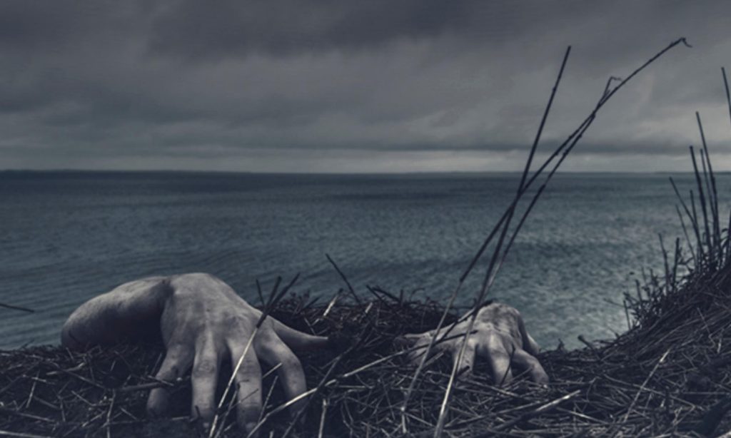 Mãos de zumbis no chão fazendo referência a The Walking Dead.