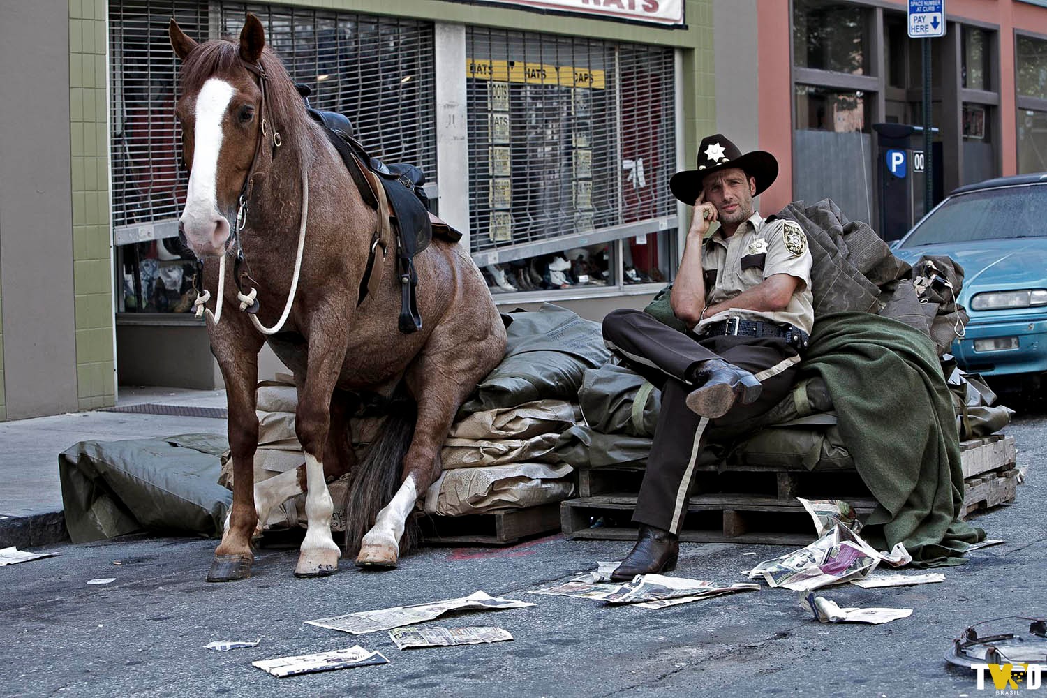 Andrew Lincoln sentado ao lado do cavalo de Rick durante um momento de descanso entre as gravações do Episódio 1 - 