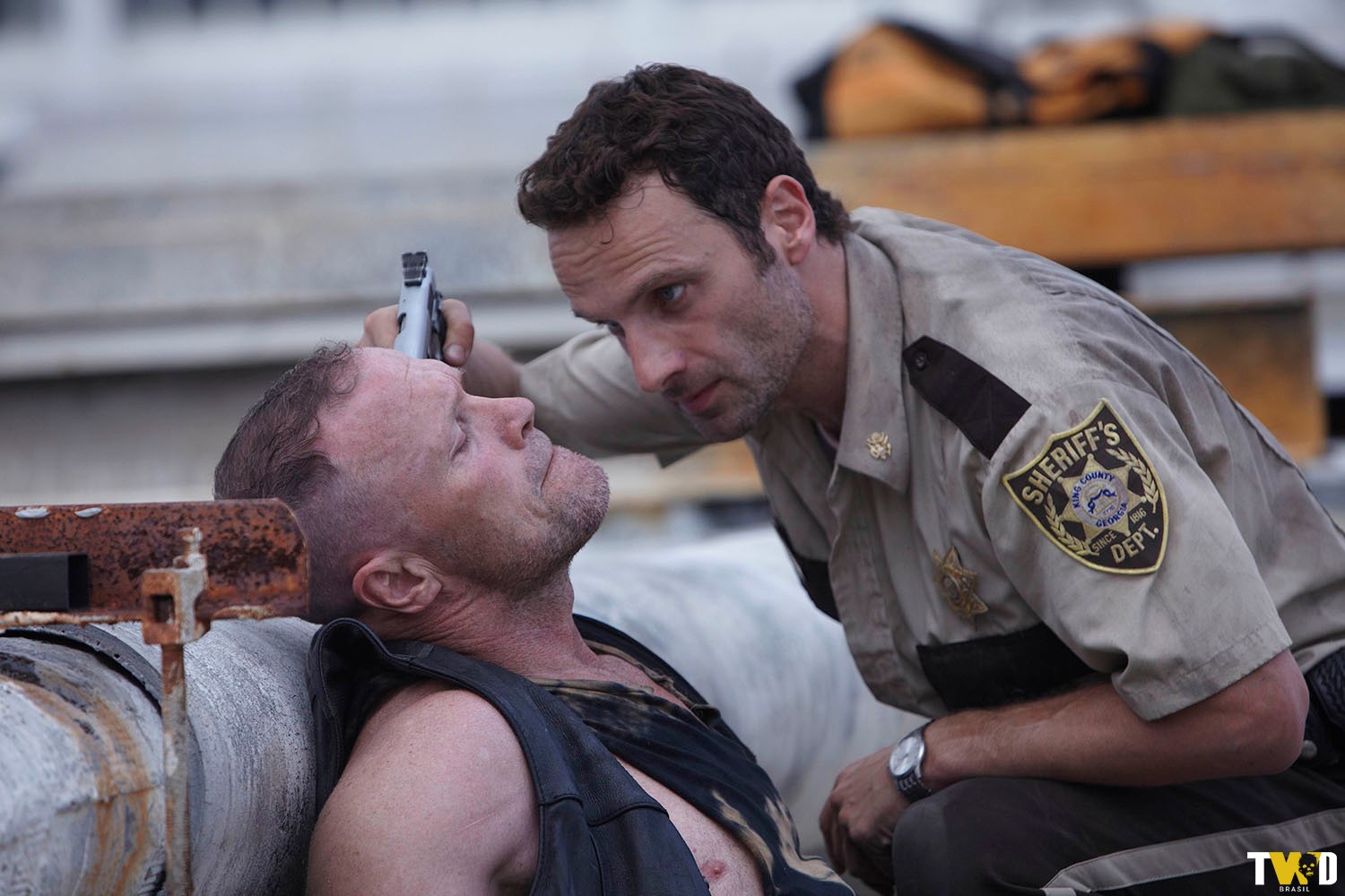 Rick (Andrew Lincoln) apontando sua arma e ameaçando Merle (Michael Rooker) no telhado da loja onde o grupo ficou preso por conta dos zumbis