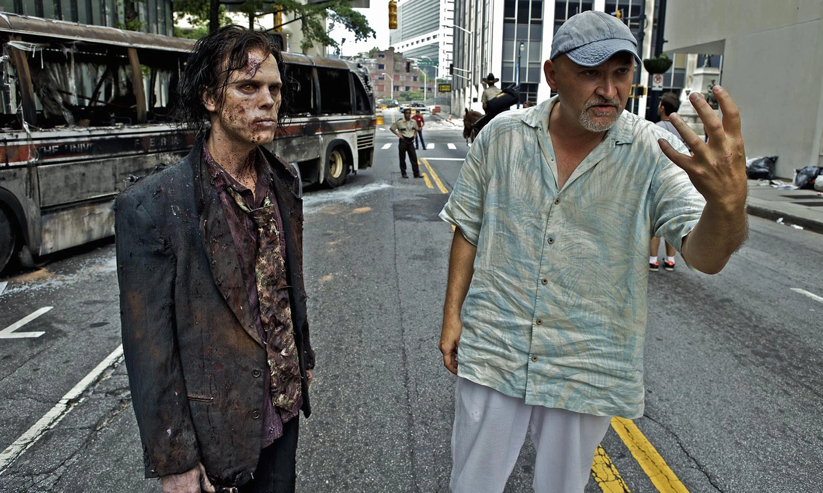 O showrunner Frank Darabont nos bastidores do primeiro episódio de The Walking Dead mostrando como um zumbi precisa atuar na cena.