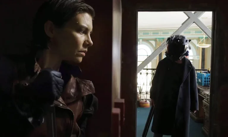 Maggie escondida e pronta para atacar um inimigo em cena de The Walking Dead: Dead City.