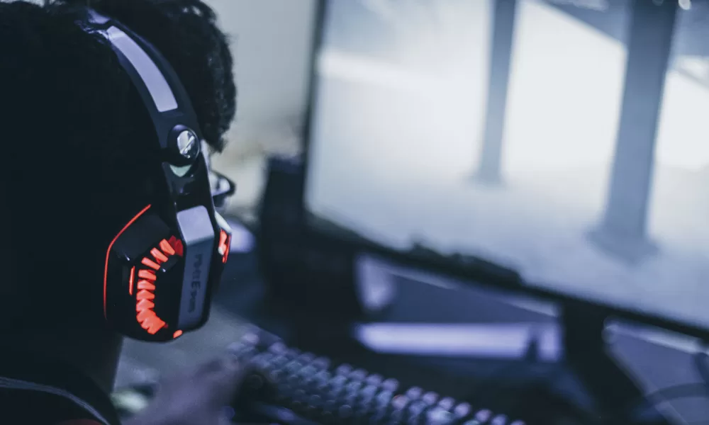 Imagem de jogador com fone de ouvido simulando jogo de The Walking Dead.