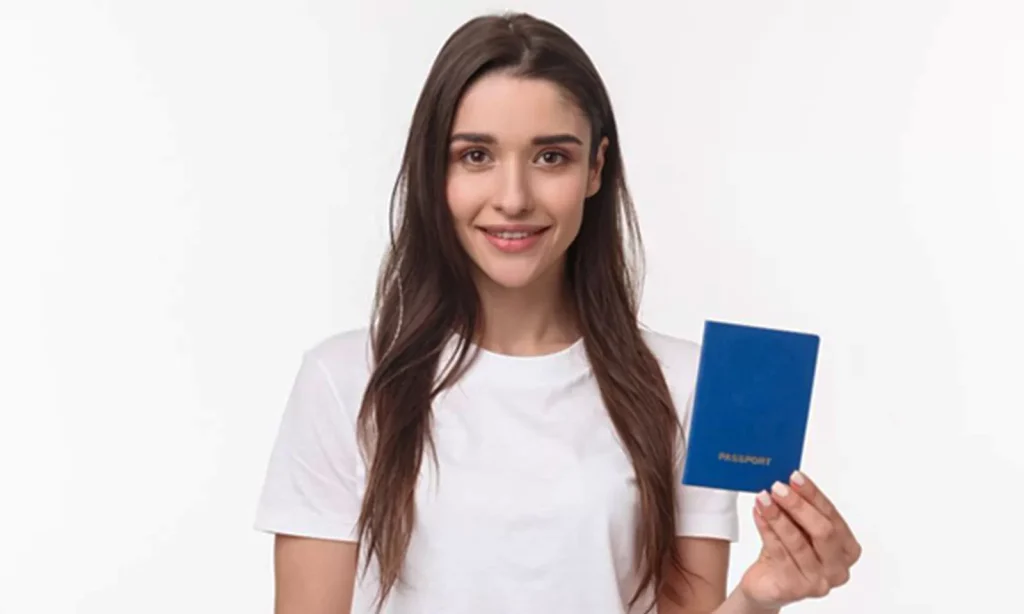Mulher segurando passaporte para ilustrar matéria.