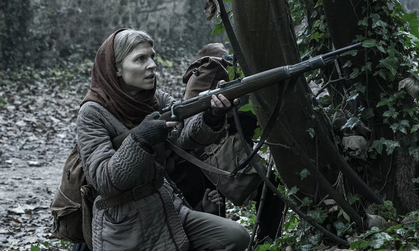 Isabelle apontando sua arma na floresta em cena do Episódio 2 da 1ª temporada de The Walking Dead: Daryl Dixon.