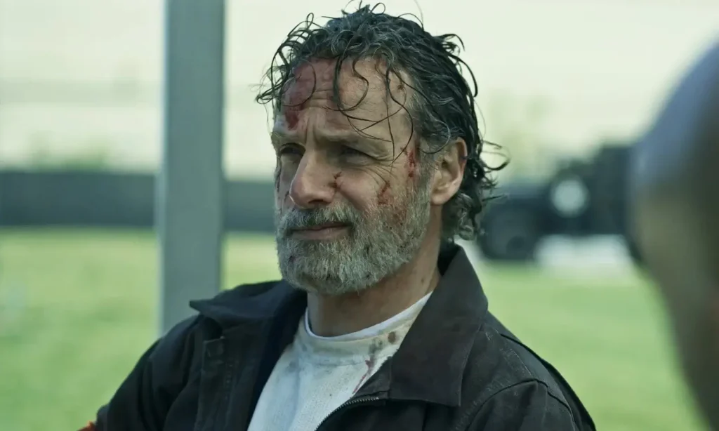 Rick Grimes sujo de sangue e conversando com alguém em cena do trailer de The Walking Dead: The Ones Who Live.