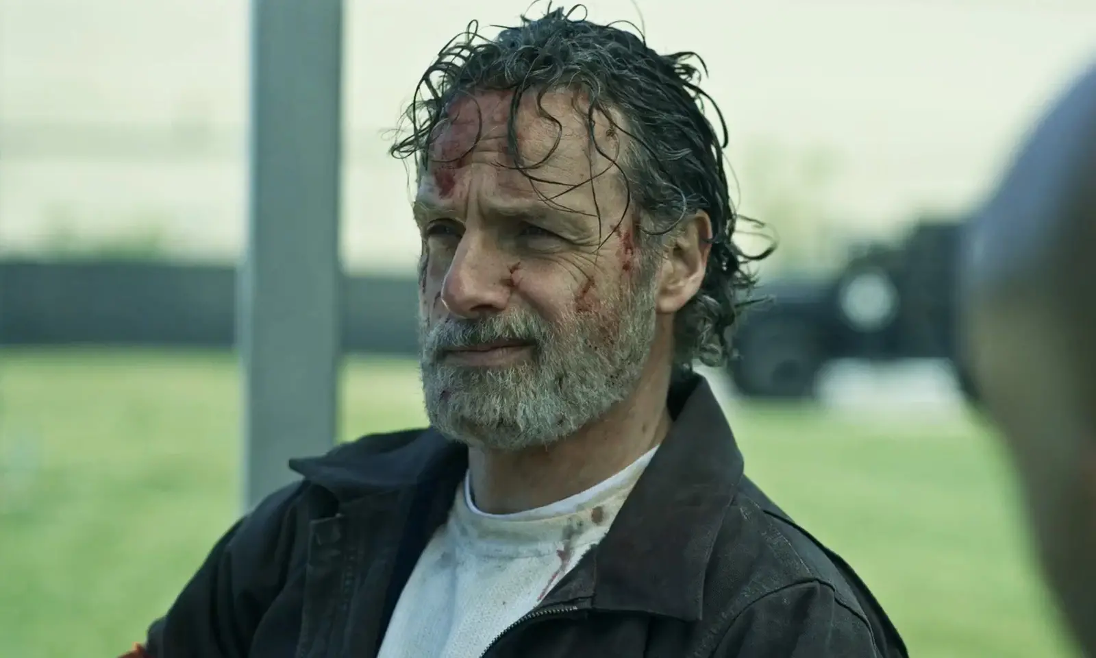 Rick Grimes sujo de sangue e conversando com alguém em cena do trailer de The Walking Dead: The Ones Who Live.