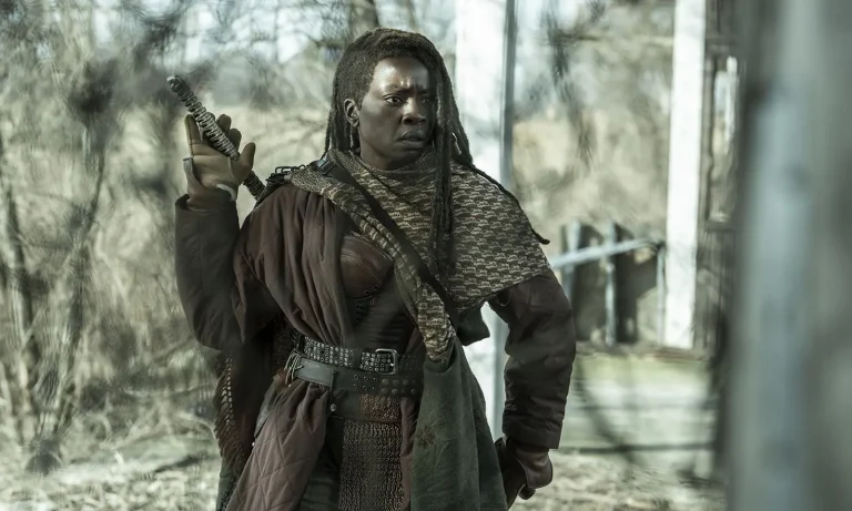 Michonne preparada para pegar sua katana e olhando para algo ou alguém em cena do Episódio 2 de The Walking Dead: The Ones Who Live.