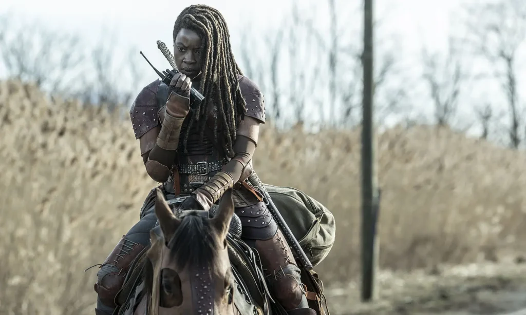 Michonne falando com alguém pelo rádio e montada em seu cavalo em cena do Episódio 2 de The Walking Dead: The Ones Who Live.