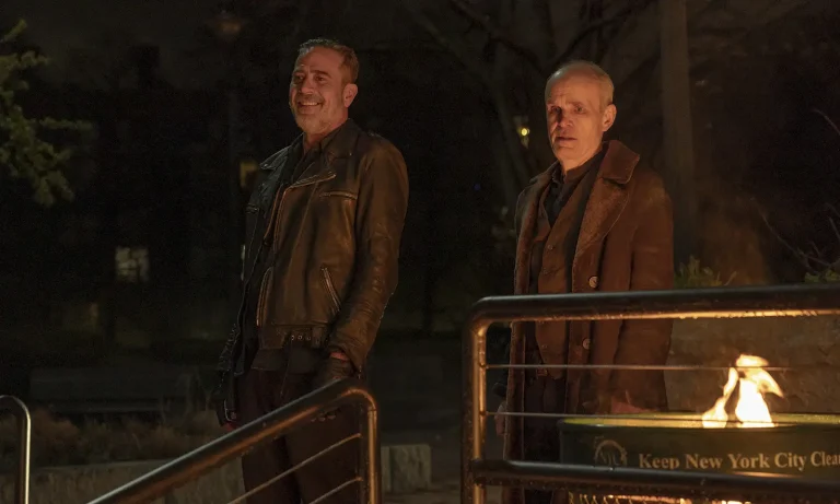 Negan sorrindo e o Croata um tanto quanto preocupado observando algo em cena do Episódio 1 da 2ª temporada de The Walking Dead: Dead City.