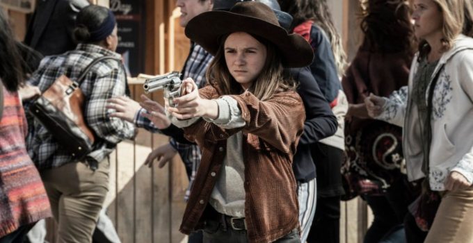 Judith Grimes apontando uma arma em meio a multidão em cena do epísódio 18 da 11ª temporada de The Walking Dead.