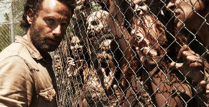 Imagem promocional com Rick na prisão e os zumbis na cerca na 4ª temporada de The Walking Dead.