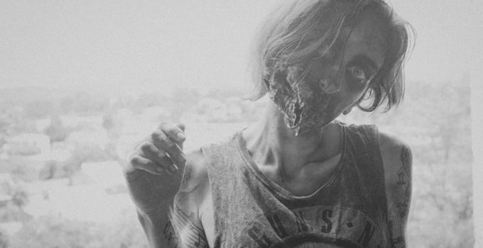 pessoa maquiada de zumbi representando The Walking Dead em imagem preto e branco