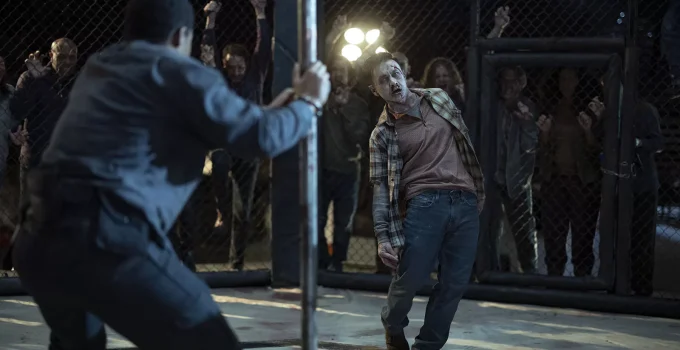 Perlie Armstrong algemado na arena do Croata enquanto um zumbi se aproxima em cena do Episódio 3 da 1ª temporada de The Walking Dead: Dead City.