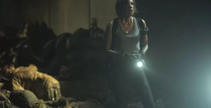 Maggie assustada no esgoto com uma lanterna olhando para algo em cena do Episódio 5 da 1ª temporada de The Walking Dead: Dead City.