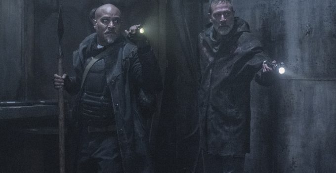 Gabriel e Negan apontando lanternas para algo no metrô do episódio 1 da 11ª e última temporada de The Walking Dead.