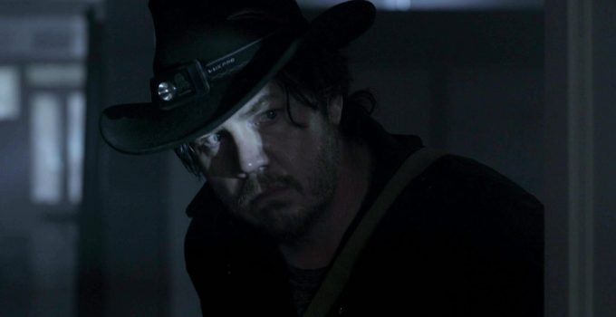 Eugene desconfiado e olhando para algo ou alguém em cena do episódio 11 da 11ª temporada de The Walking Dead.