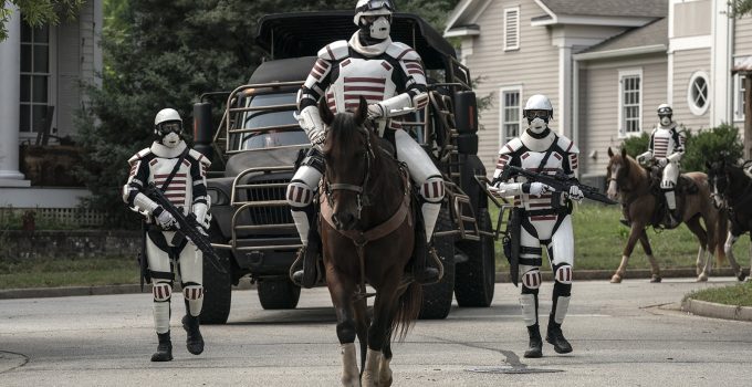 Dois soldados de Commonwealth a cavalo e dois andando em Alexandria no episódio 12 da 11ª temporada de The Walking Dead.