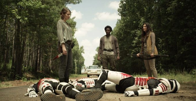 Maggie, Elijah e Lydia olhando para soldados de Commonwealth mortos na estrada no episódio 13 da 11ª temporada de The Walking Dead.