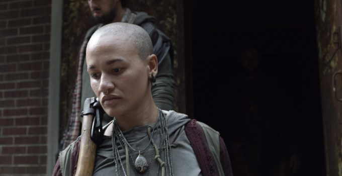 Personagem desconhecida segurando sua arma em cena do episódio 13 da 11ª temporada de The Walking Dead.