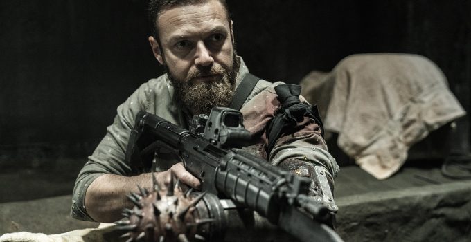 Aaron apontando sua arma em cena do episódio 18 da 11ª temporada de The Walking Dead.