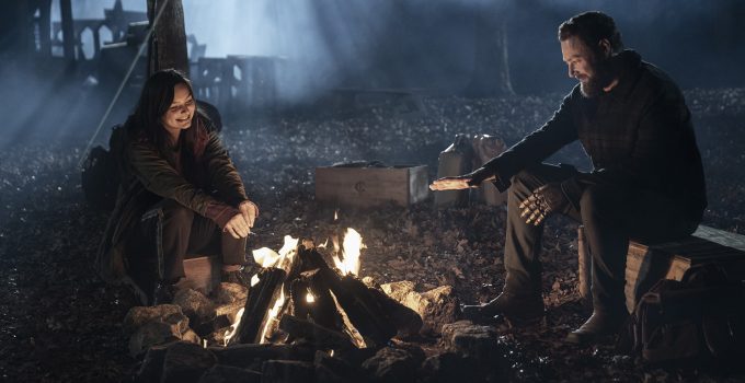 Aaron e Lydia sentados a noite ao redor da fogueira em cena do episódio 19 da 11ª temporada de The Walking Dead.