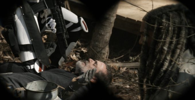 Negan sendo rendido no chão por um soldado de Commonwealth com Ezekiel de lado em cena do episódio 22 da 11ª temporada de The Walking Dead.