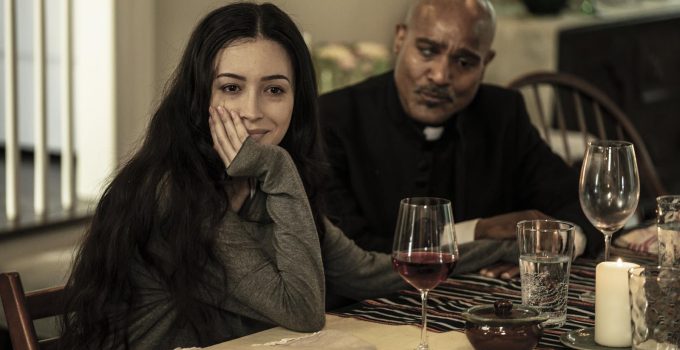 Rosita sentada a mesa segurando a mão de Gabriel em cena do último episódio de The Walking Dead.