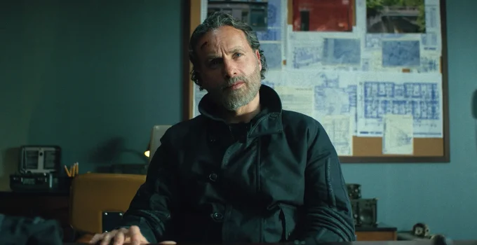 Rick sentado na base da CRM e olhando para algo ou alguém em cena do Episódio 6 de The Walking Dead: The Ones Who Live.